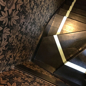 black and gold wallpaper on staircase in victorian home